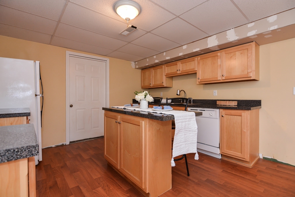 73 Drew Road Derry, NH 03038 - Photo 33 of 42 a kitchen with granite countertop wooden floors and white stainless steel appliances