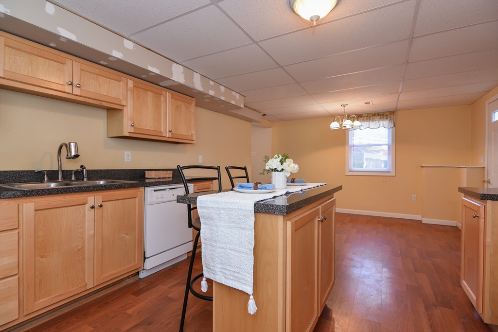 73 Drew Road Derry, NH 03038 - Photo 34 of 42 a kitchen with stainless steel appliances granite countertop a sink a microwave cabinets and wooden floor