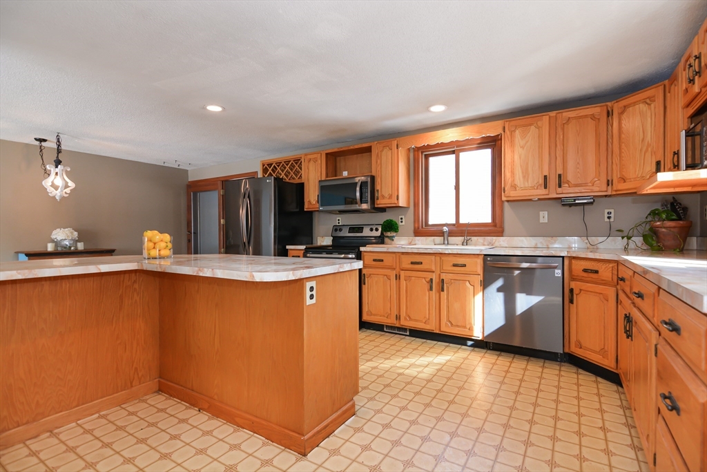 73 Drew Road Derry, NH 03038 - Photo 10 of 42 a kitchen with stainless steel appliances granite countertop a stove a sink dishwasher and a refrigerator