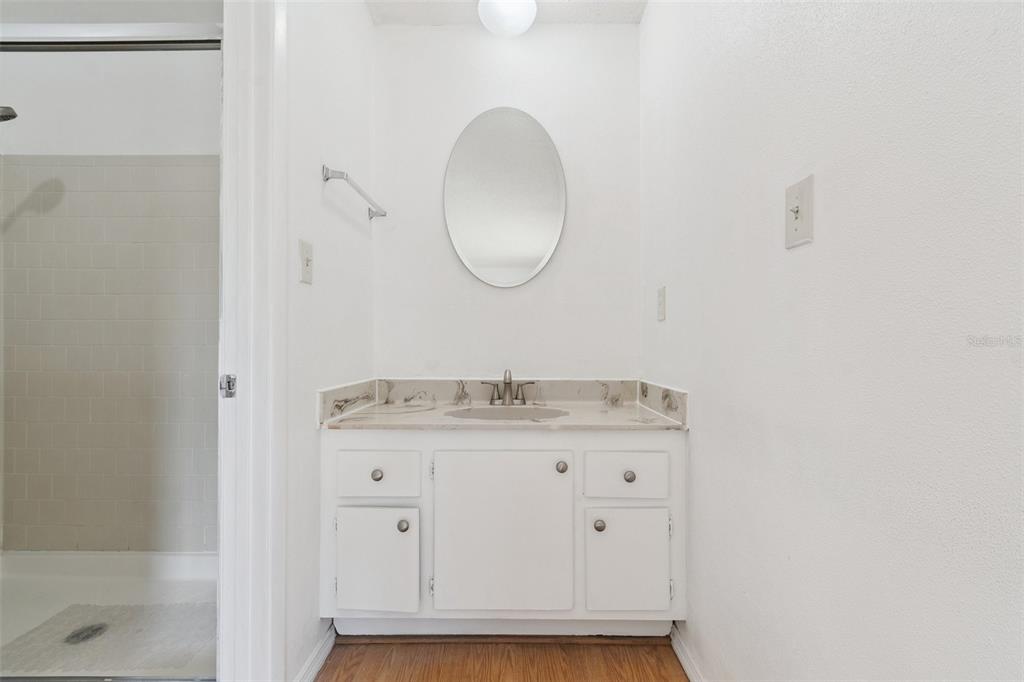 2811 Southwest Archer Road, Unit A2 Gainesville, FL 32608 - Photo 19 of 26 a bathroom with a granite countertop sink a mirror and a vanity