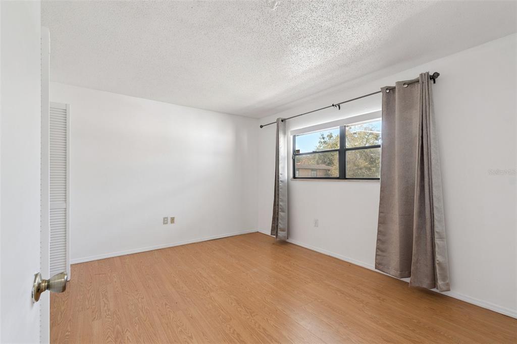 2811 Southwest Archer Road, Unit A2 Gainesville, FL 32608 - Photo 21 of 26 a view of an empty room with wooden floor and a window