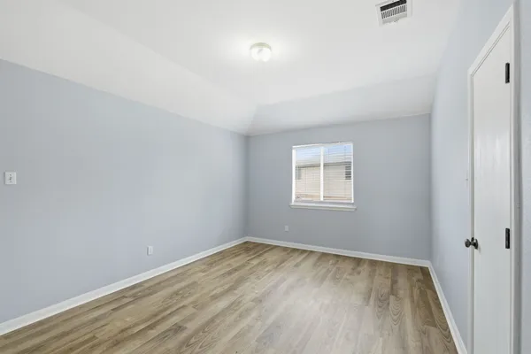 a view of a room with wooden floor and window