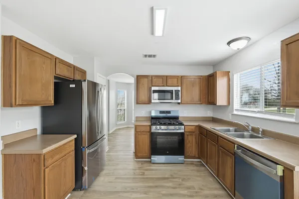 a kitchen with stainless steel appliances granite countertop a refrigerator stove and sink