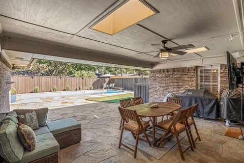 a view of a patio with a table and chairs under an umbrella