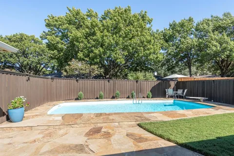 a backyard of a house with table and chairs