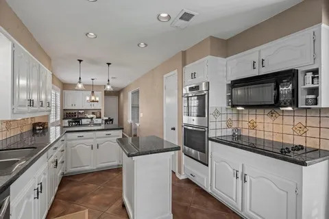 a kitchen with stainless steel appliances a stove sink microwave and cabinets