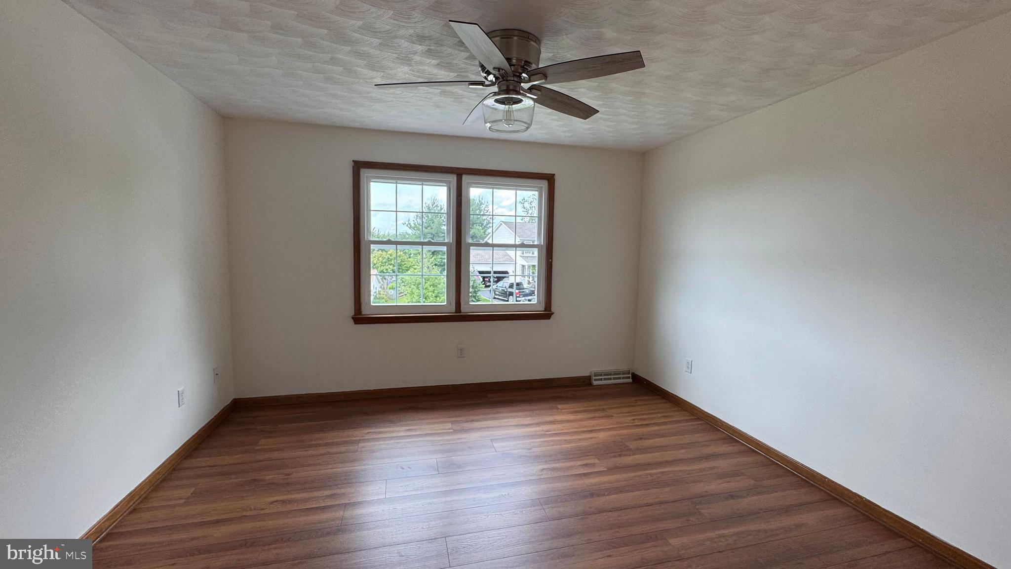 345 Jasmine Drive Hanover, PA 17331 - Photo 33 of 80 an empty room with wooden floor chandelier fan and windows