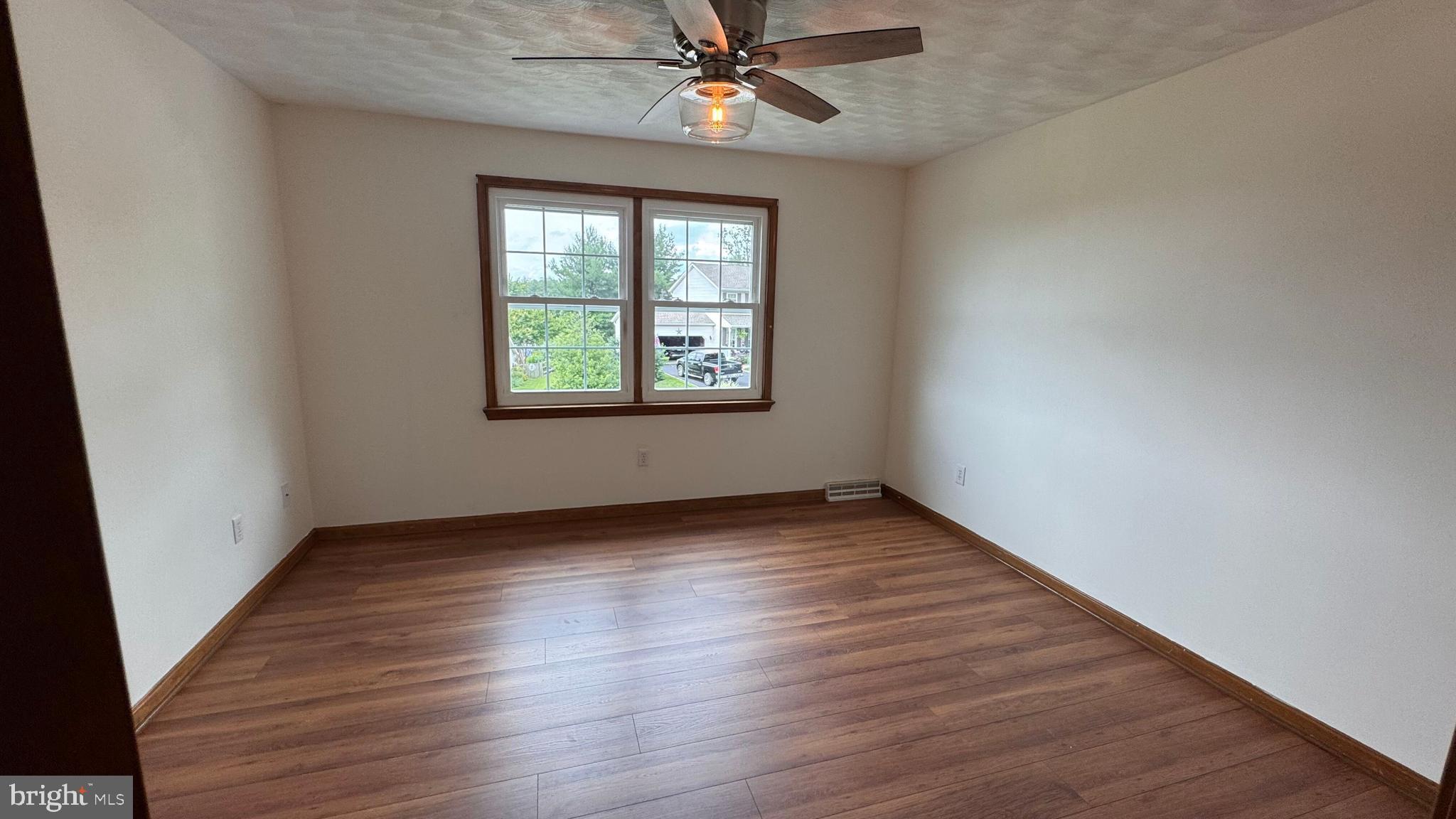 345 Jasmine Drive Hanover, PA 17331 - Photo 35 of 80 an empty room with wooden floor chandelier fan and windows