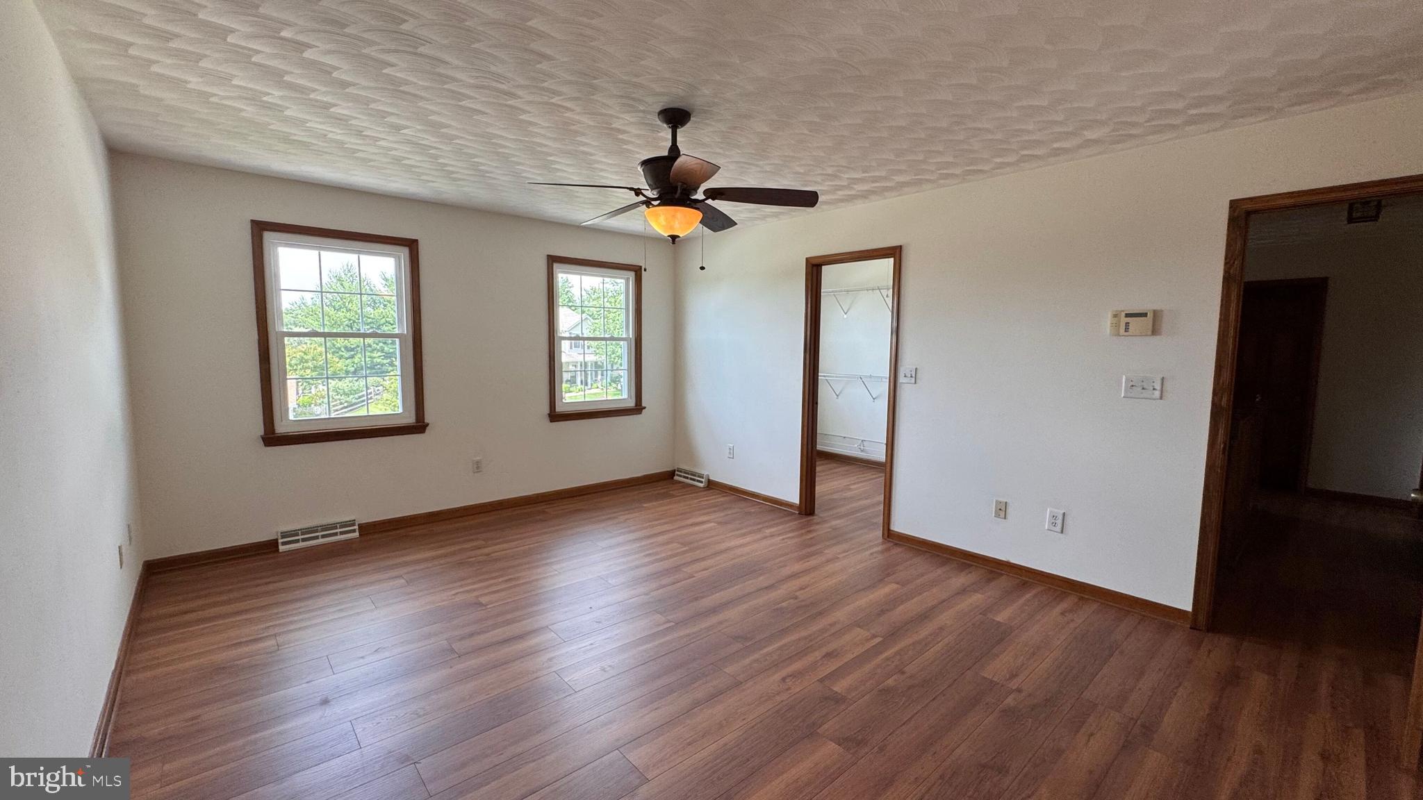 345 Jasmine Drive Hanover, PA 17331 - Photo 62 of 80 an empty room with wooden floor chandelier fan and windows
