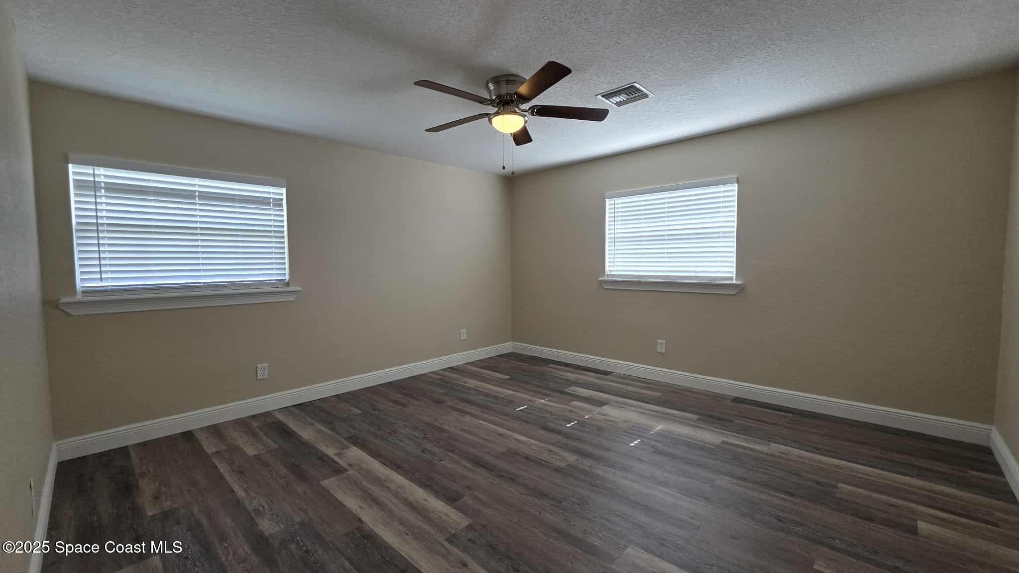 410 4th Street Merritt Island, FL 32953 - Photo 18 of 37 a view of an empty room with wooden floor and a window
