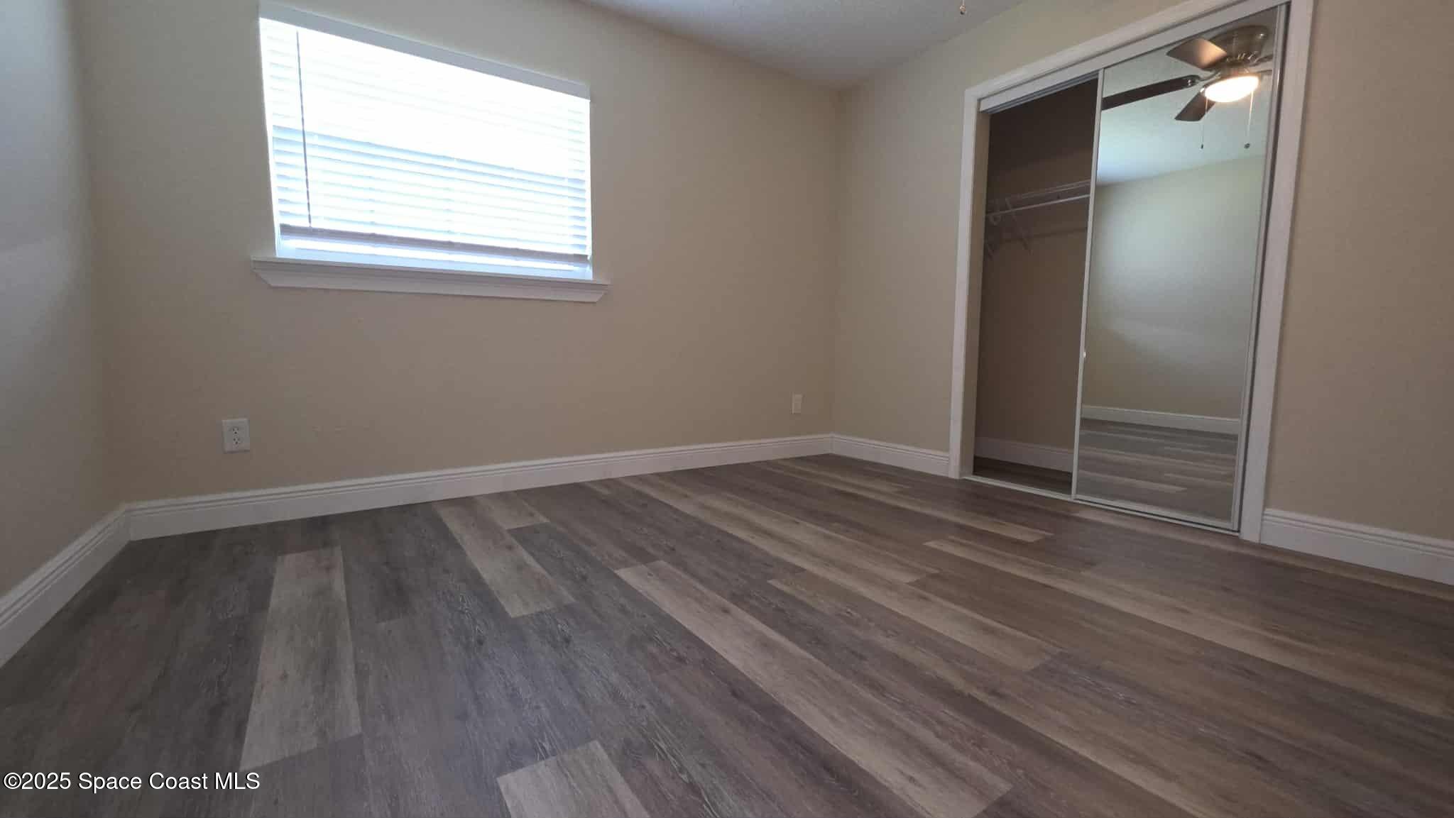 410 4th Street Merritt Island, FL 32953 - Photo 23 of 37 an empty room with wooden floor and windows