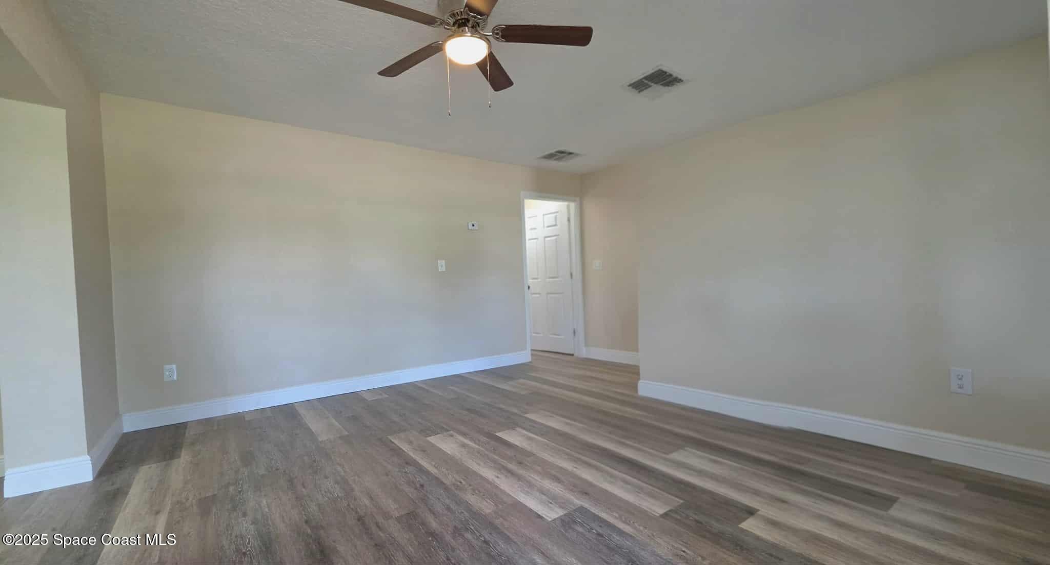 410 4th Street Merritt Island, FL 32953 - Photo 26 of 37 a view of an empty room with wooden floor