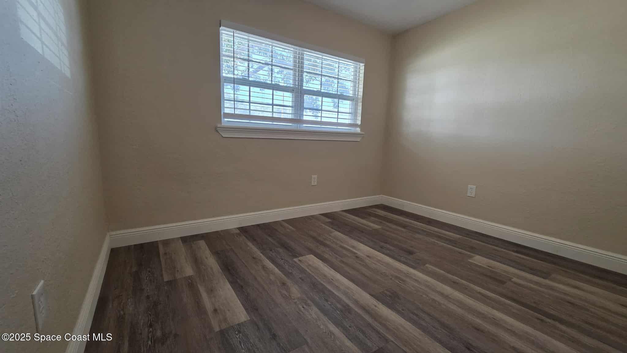 410 4th Street Merritt Island, FL 32953 - Photo 27 of 37 an empty room with wooden floor and windows