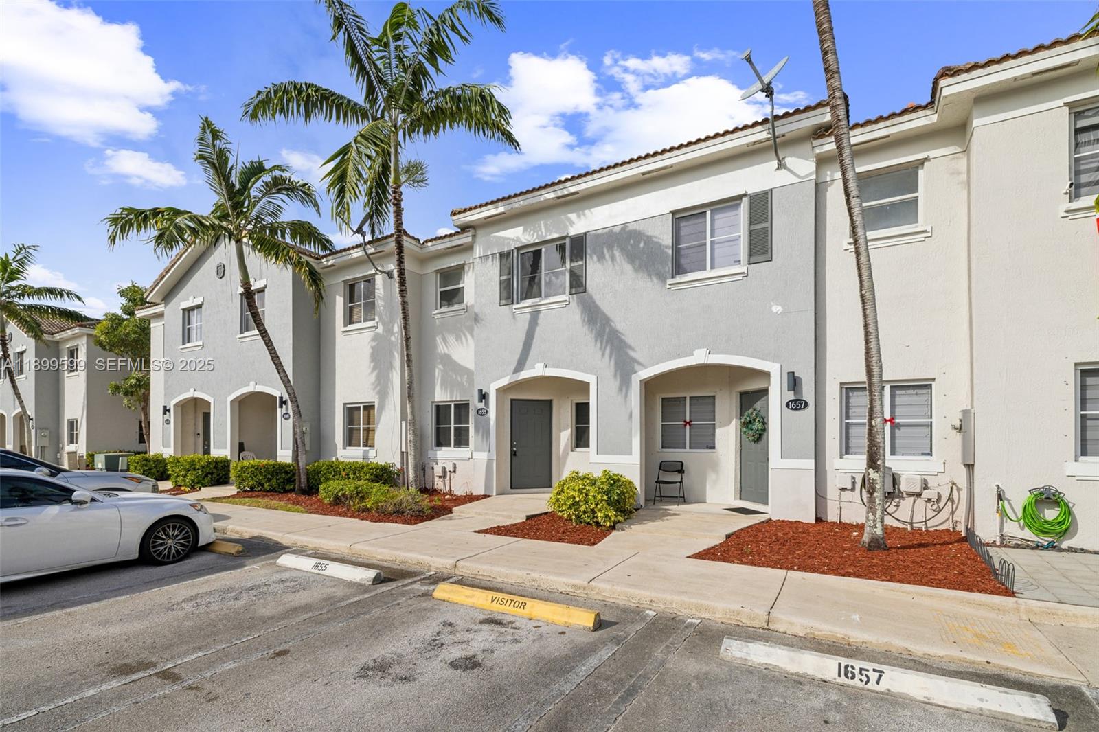 1655 Southeast 30th Street Homestead, FL 33035 - Photo 3 of 17 a front view of a building with lots of cars and palm trees