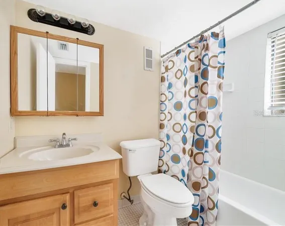 a bathroom with a sink a toilet and shower curtain