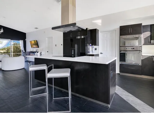 a kitchen with a dining table chairs cabinets and stainless steel appliances