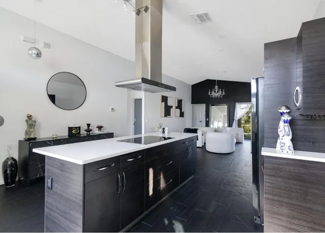 a kitchen with a sink dishwasher and a stove with wooden floor