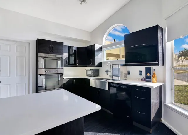 a kitchen with stainless steel appliances a sink microwave and cabinets