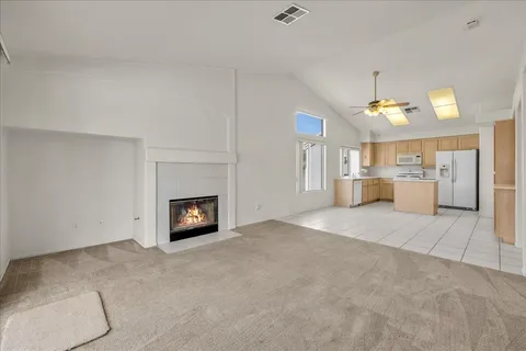 a view of a kitchen with a fireplace and a chandelier fan