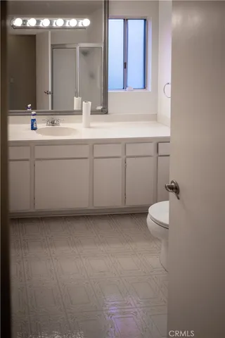 a bathroom with a sink vanity mirror and toilet