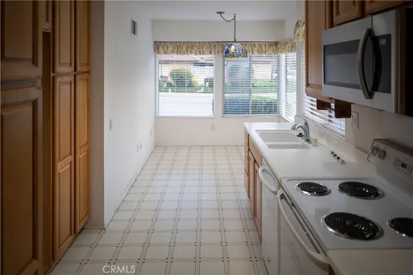 a kitchen with kitchen island a sink a stove and a refrigerator