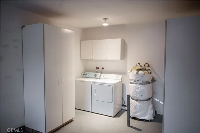 a utility room with cabinets washer and dryer