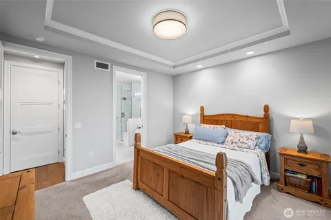 a bedroom with a bed and a dresser with wooden floor