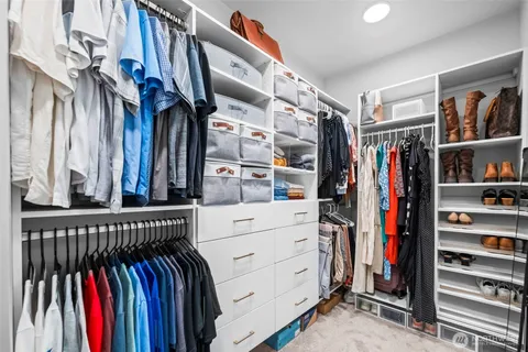 a view of walk in closet with clothes and shoes