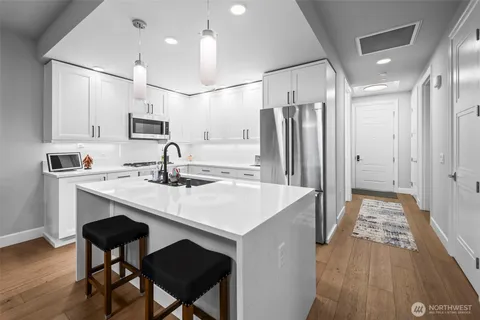 a kitchen with stainless steel appliances a sink stove and refrigerator