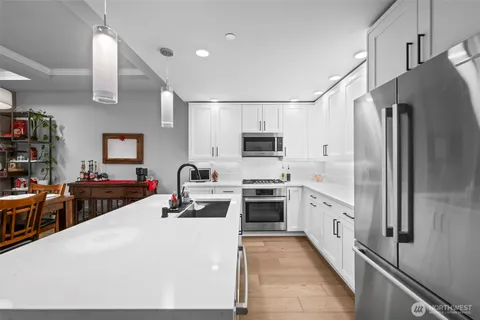 a kitchen with stainless steel appliances a stove refrigerator sink and cabinets
