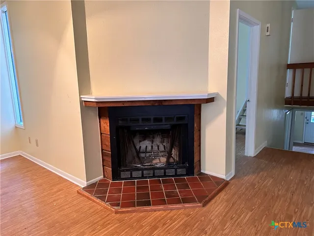 a living room with a fireplace and a wooden floor