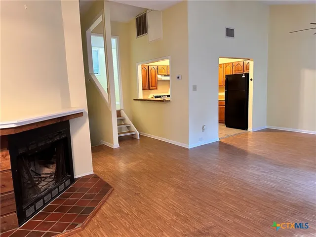 a view of a livingroom with wooden floor and a fireplace