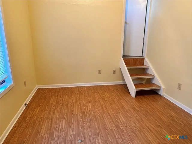 a view of a room with wooden floor and white walls