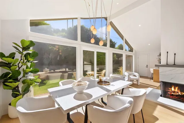 a dining room with furniture a potted plant and a kitchen view