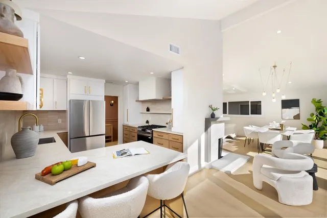 a kitchen with stainless steel appliances kitchen island granite countertop a dining table and chairs