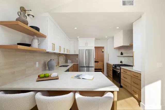 a kitchen with stainless steel appliances a dining table and chairs