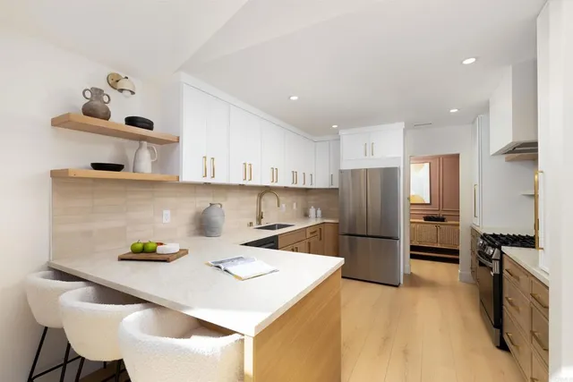 a kitchen with stainless steel appliances granite countertop a refrigerator and a stove top oven
