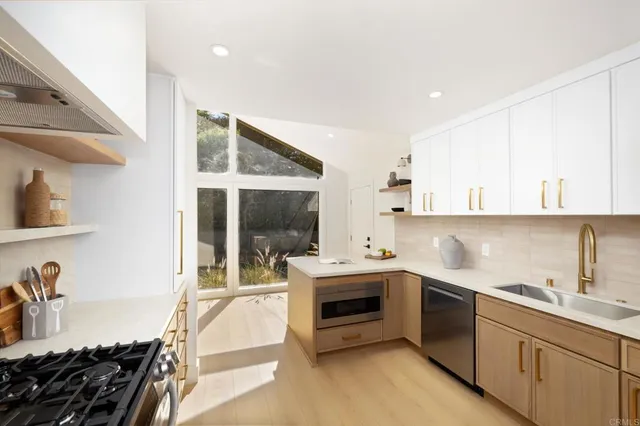 a kitchen with sink stove and cabinets