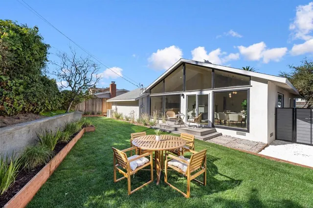 a view of a chair and table in backyard of the house