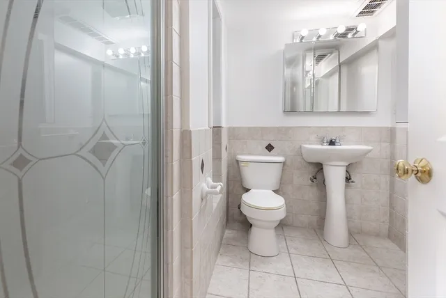 a bathroom with a toilet sink and mirror