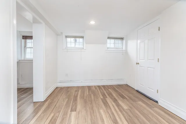 a view of a room with wooden floor and white walls