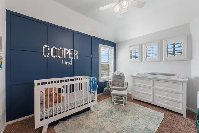 a bedroom with a bed and dresser with mirror