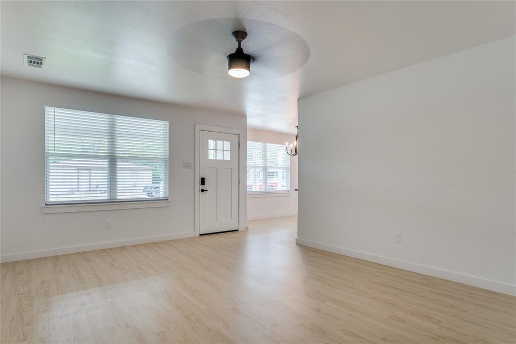 507 Campbell Street Terrell, TX 75160 - Photo 3 of 13 an empty room with wooden floor and windows