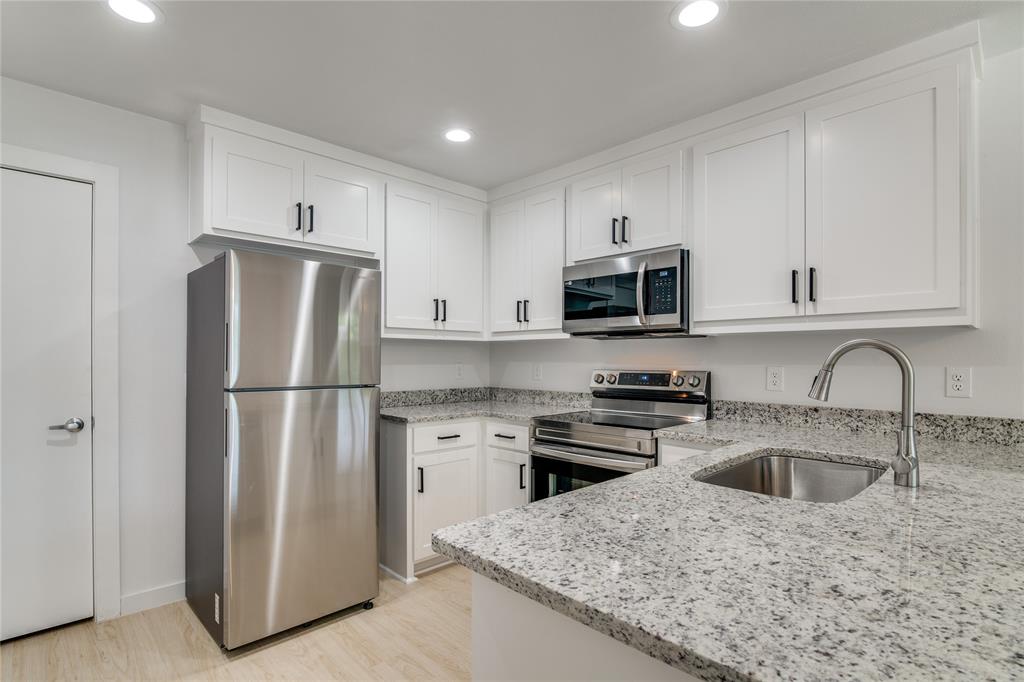 507 Campbell Street Terrell, TX 75160 - Photo 4 of 13 a kitchen with refrigerator a microwave a sink and cabinets