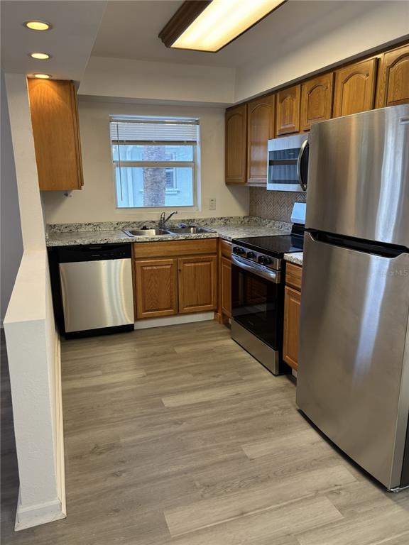 9030 Blind Pass Road, Unit C7 St. Petersburg, FL 33706 - Photo 5 of 16 a kitchen with stainless steel appliances granite countertop a refrigerator sink and stove