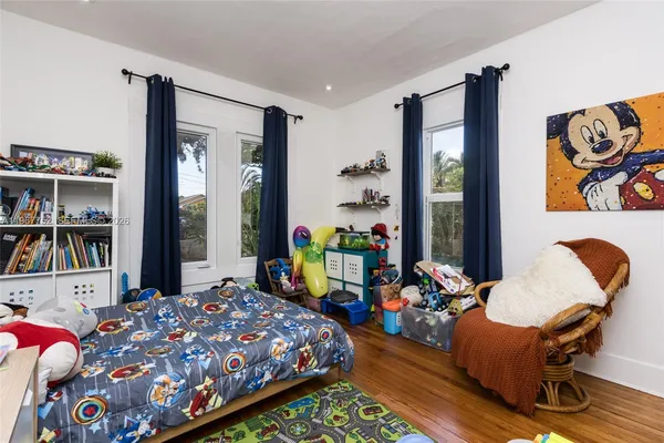 a bedroom with a bed and a wooden floor