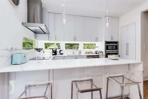 a kitchen with stainless steel appliances kitchen island granite countertop a refrigerator and a stove