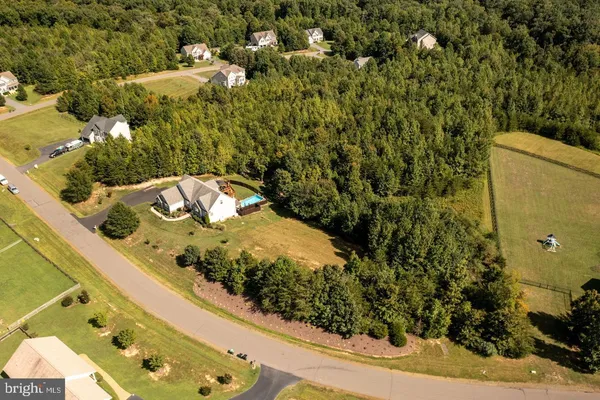 an aerial view of a residential houses with yard