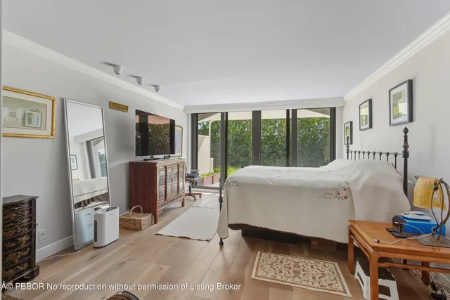 a living room with furniture a flat screen tv and a floor to ceiling window