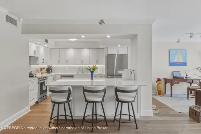 a kitchen with a dining table chairs and white cabinets